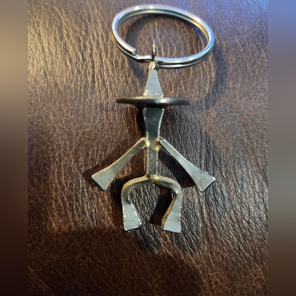 This is a handmade metal cowboy figure keychain made from welded horseshoe nails